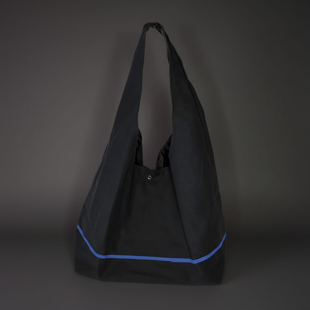 Black tote bag with a blue stripe on a dark gray background