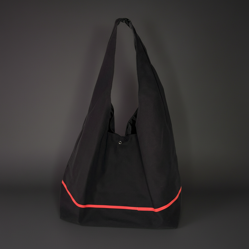 Black tote bag with a red accent on a dark gray background